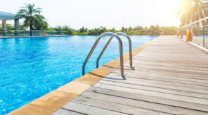 Piscine avec des margelles et terrasse en bois