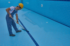 Monsieur qui nettoie piscine